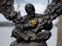 Des fleurs reposent dans les bras de la statue de Gordon Lightfoot à Orillia, en Ontario, après le décès de l'auteur-compositeur-interprète canadien cette semaine à l'âge de 84 ans.