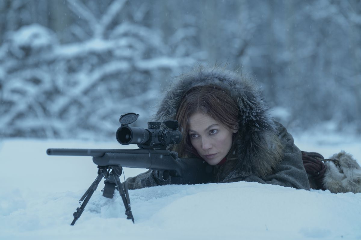 Jennifer Lopez se couche avec un fusil de sniper dans la neige, avec un lourd manteau de fourrure, dans The Mother.