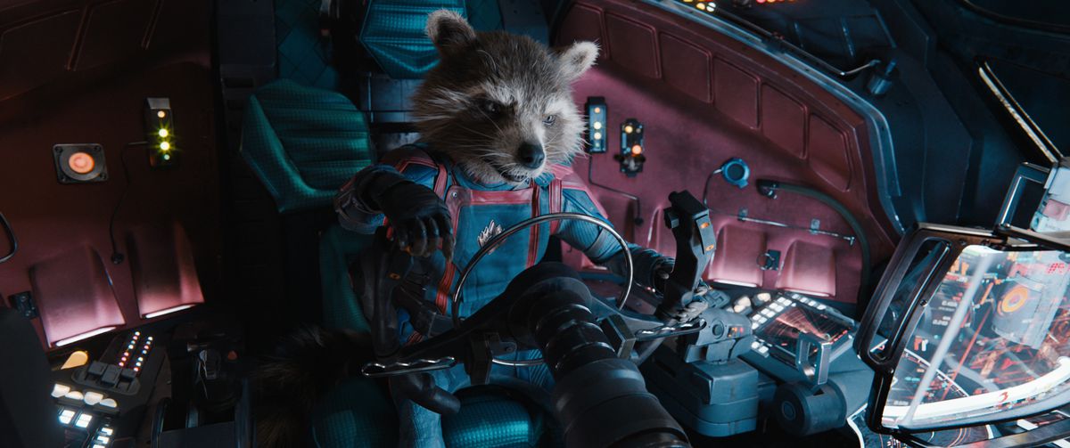 Le raton laveur anthropomorphe Rocket (corps joué par Sean Penn, exprimé par Bradley Cooper) est assis dans le cockpit d'un vaisseau spatial en uniforme de combinaison bleu et rouge des Gardiens de la Galaxie dans Les Gardiens de la Galaxie Vol.  3