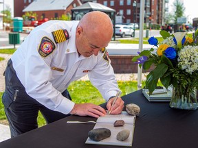 Le chef Mario Villeneuve du service d'incendie de Clarence-Rockland a signé le livre de condoléances à la mémoire du sergent de l'OPP.  Eric Mueller à la mairie de Rockland samedi.