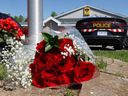 Des fleurs ont été déposées au détachement de la Police provinciale de l'Ontario à Embrun, en Ontario, vendredi, au lendemain d'une fusillade à Bourget qui a laissé le Sgt.  Mort d'Eric Mueller. 