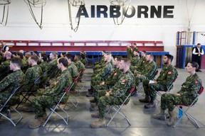 Des membres des Forces canadiennes, qui participent aux efforts de secours contre les incendies de forêt, écoutent une séance d'information avec le premier ministre Justin Trudeau à la BFC Edmonton dans le comté de Sturgeon, en Alberta, le 15 mai 2023.
