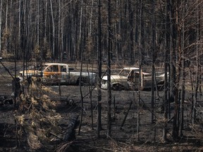 Des camions incendiés par un feu de forêt sont assis sur une propriété près de Drayton Valley, en Alberta,