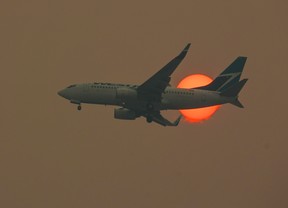 Un Boeing 737 de WestJet descend à travers la fumée d'un incendie de forêt alors que le soleil se lève à Calgary le mardi 16 mai 2023. Une grève chez WestJet pourrait commencer dès vendredi. Gavin Young/Postmedia