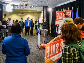 La dirigeante de l'UCP, Danielle Smith, au premier plan à gauche, attend que les manifestants perturbent une conférence de presse à Calgary le jeudi 11 mai 2023.