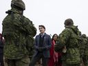 Le premier ministre canadien Justin Trudeau et la ministre de la Défense Anita Anand s'entretiennent avec les troupes canadiennes déployées dans le cadre de l'opération Reassurance alors qu'il visite la base militaire d'Adazi à Adazi, en Lettonie, le mardi 8 mars 2022. LA PRESSE CANADIENNE/Adrian Wyld