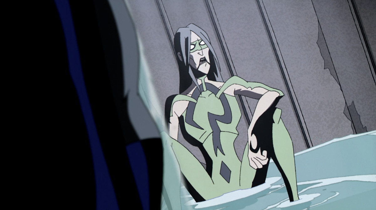 Le Riddler, assis par terre portant un costume vert moulant avec un point d'interrogation et un masque