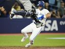 Whit Merrifield des Blue Jays marque sur un vol sacrifié de Vladimir Guerrero Jr. alors que le receveur des Yankees de New York Kyle Higashioka saute dans les airs lors de la septième manche à Toronto, le jeudi 18 mai 2023. 