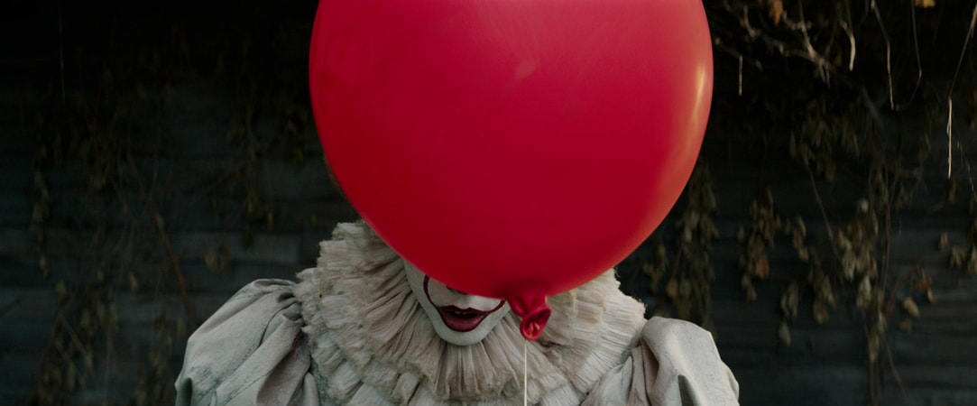 Un ballon rouge obscurcit le visage de Pennywise le Clown (Bill Skarsgård) dans Ça.