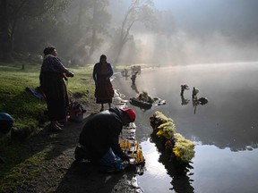 Les peuples autochtones du Guatemala exécutent la cérémonie de « Prière pour la pluie » sur les rives de la lagune de Chicabal.  Il s'est formé dans le cratère d'un volcan éteint et les Mayas le considèrent comme un lieu sacré.  Johan Ordonez/AFP via Getty Images
