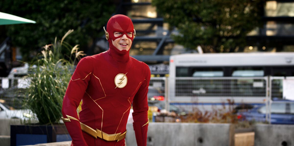 Grant Gustin en tant que Flash en costume souriant alors qu'il est sur le point de se lancer dans un sprint dans The CW's The Flash