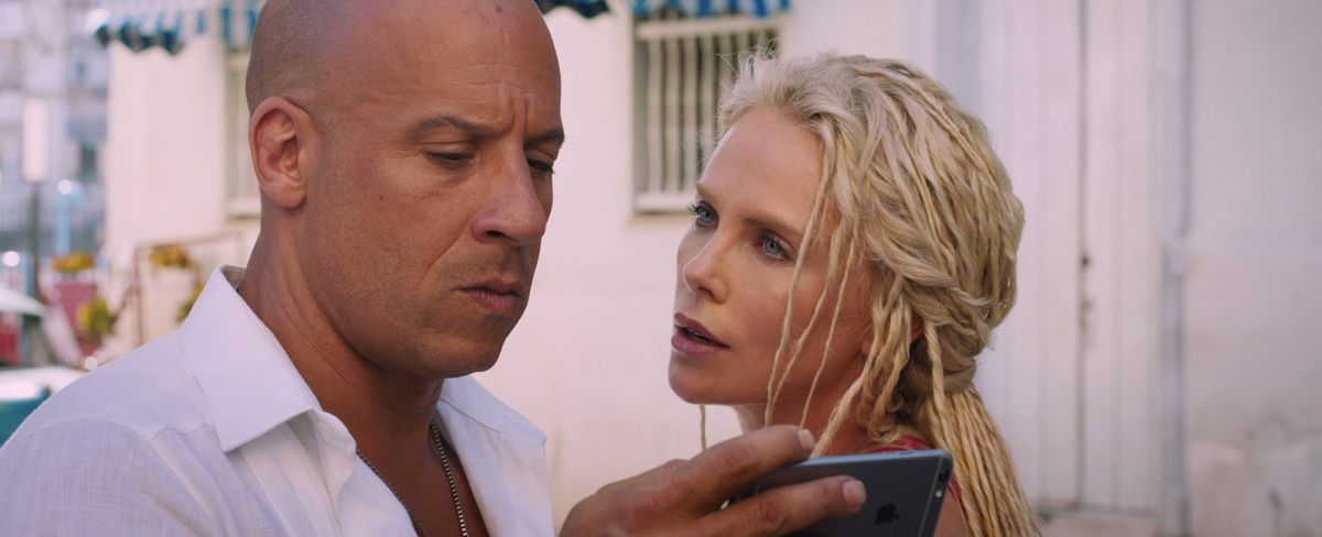 Dom Toretto (Vin Diesel) regarde un téléphone pendant que Cipher (Charlize Theron) regarde dans F8 : Le destin des furieux