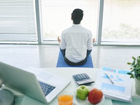 Un homme d'affaires faisant du yoga dans son bureau