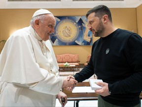 Cette photo prise et publiée sous forme de document le 13 mai 2023 par les médias du Vatican montre que le pape François serre la main du président ukrainien Volodymyr Zelensky à la suite d'une audience privée au Vatican.