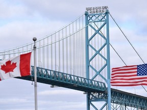 Des drapeaux canadiens et américains flottent près du pont Ambassador au passage frontalier Canada-États-Unis à Windsor, en Ontario.  le samedi 21 mars 2020. L'administration Biden indique que les exigences de vaccination contre la COVID-19 pour les voyageurs aériens étrangers et à la frontière canado-américaine sont levées à compter du 12 mai.