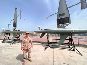 Le commandant de la marine espagnole Jorge Lens avec des USV solaires et hydroélectriques Saildrone Explorer à la base navale américaine de Bahreïn.