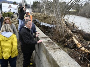 Le premier ministre du Québec, François Legault, observe le débit de la rivière du Gouffre alors qu'il visite le site d'une importante inondation printanière, le mercredi 3 mai 2023, à Baie-St-Paul, au Québec.