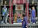 Une femme passe devant une devanture de magasin mettant en vedette le roi Charles III à Londres le mardi 2 mai 2023. Des foules du monde entier, y compris du Canada, commençaient à se rassembler à Londres avant le couronnement du roi Charles.