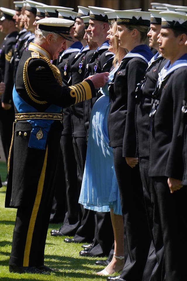 Le roi présente une assistante médicale enceinte de sept mois Paisley Chambers-Smith avec l'Ordre royal de Victoria et d'autres membres de la Royal Navy pour leur part dans le cortège funèbre de la reine Elizabeth II, sur le quadrilatère du château de Windsor