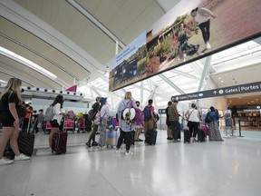 Les gens font la queue avant d'entrer dans la sécurité à l'aéroport international Pearson de Toronto le vendredi 5 août 2022.