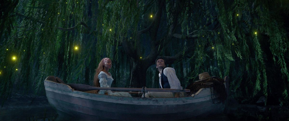 Ariel et Eric assis aux extrémités opposées d'un canot dans un lagon bleu.