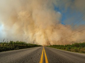 La fumée d'un feu de forêt traverse une route en Colombie-Britannique dans cette image non datée fournie par le BC Wildfire Service.  Un nouvel incendie incontrôlable dans l'intérieur de la Colombie-Britannique a déclenché un ordre d'évacuation obligatoire dans une zone située à environ 600 kilomètres au nord de Vancouver.