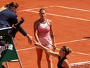 L'Ukrainienne Marta Kostyuk serre la main de l'arbitre avant d'éviter de serrer la main d'Aryna Sabalenka alors qu'elle surveille leur match du premier tour du simple féminin le premier jour de Roland Garros le 28 mai 2023 à Paris, France.