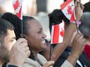 Des participants à une cérémonie de citoyenneté à Ottawa agitent des drapeaux canadiens.  Le gouvernement fédéral dit qu'il ciblera cet été les charpentiers, les plombiers, les professionnels de la santé et les francophones de l'étranger pour l'immigration au Canada.