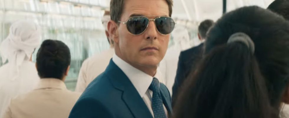 Tom Cruise stands in a crowd wearing sunglasses in Mission: Impossible - Dead Reckoning Part One.