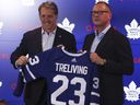 Le président des Maple Leafs de Toronto, Brendan Shanahan (à gauche) et Brad Treliving brandissent un chandail de l'équipe.