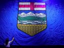 Un travailleur repasse un drapeau géant de l'Alberta tout en préparant la scène pour la soirée électorale provinciale du Parti conservateur uni à Calgary le 29 mai 2023.