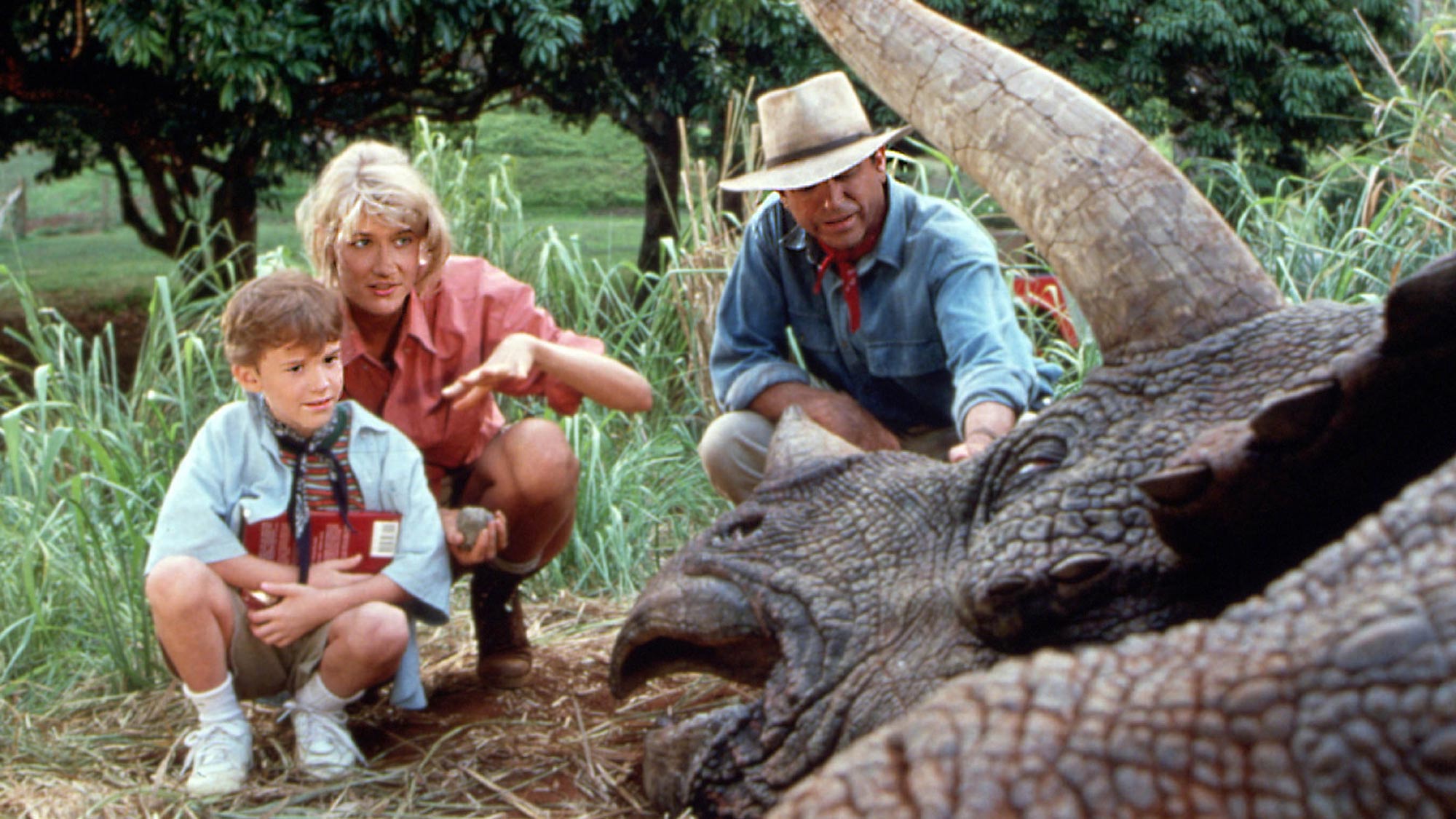 (De gauche à droite) Laura Dern dans le rôle du Dr Ellie Sattler et Sam Neill dans le rôle du Dr Alan Grant dans Jurassic Park, regardant un dinosaure blessé ou mort avec un jeune enfant