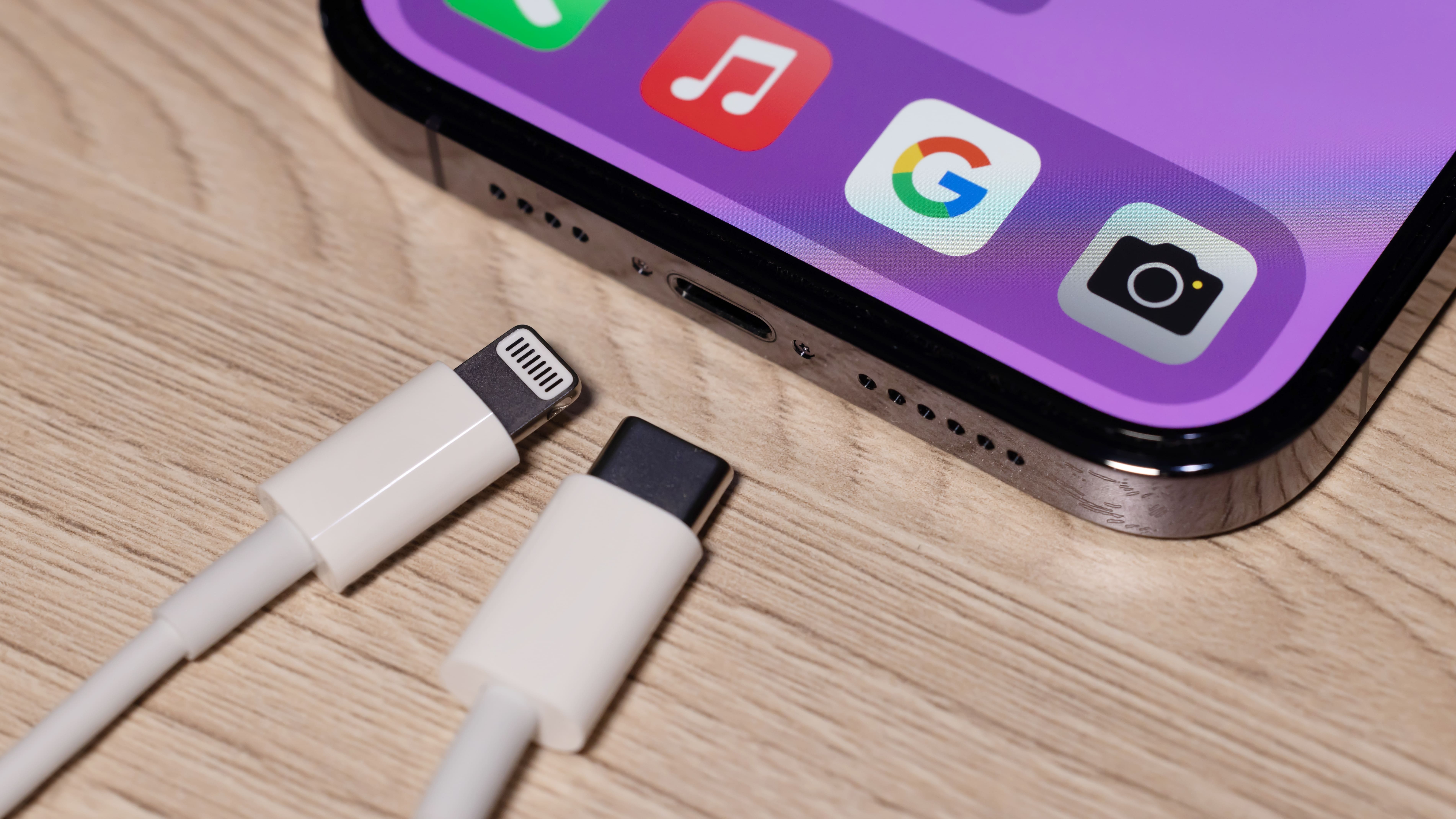 Un chargeur Lightning et un chargeur USB-C à côté d'un iPhone 14