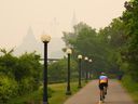 Un cycliste roule alors que la fumée des incendies de forêt en Ontario et au Québec obscurcit la colline du Parlement à Ottawa le mardi 6 juin 2023.