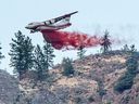 Un avion-citerne Conair laisse tomber un ignifuge sur une partie de l'incendie de forêt de Nk'Mip Creek près d'Osoyoos, en Colombie-Britannique, au Canada, le 20 juillet 2021. 