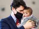 Le premier ministre Justin Trudeau tient l'enfant d'Ahmed Hussen, qui est ministre du Logement, de la Diversité et de l'Inclusion, lors d'une conférence de presse pour annoncer un nouvel accord sur la garde d'enfants avec l'Ontario en mars 2022.