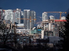 Des grues de construction dominent des condos en construction près du sud-est de False Creek à Vancouver le 9 février 2020.
