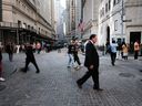 Les gens marchent le long de Wall Street près de la Bourse de New York.  Les chefs de Wall Street ont été parmi les plus bruyants à faire pression pour un retour au bureau cinq jours par semaine.