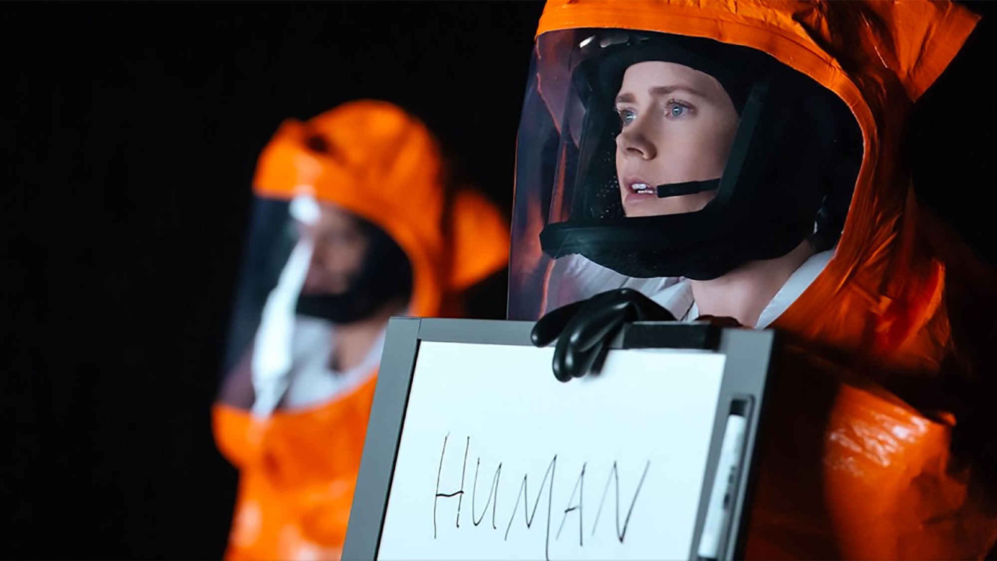 Amy Adams brandit une pancarte indiquant HUMAN dans Arrival