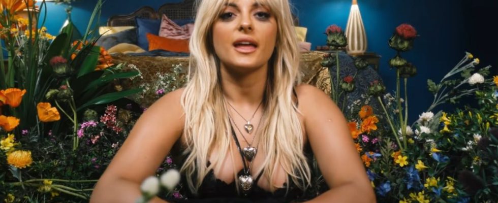 Bebe Rexha talking to the camera from the flower set of her music video Sabotage.
