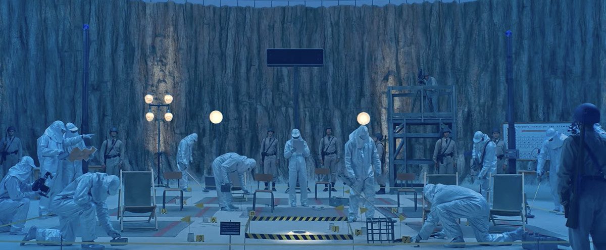 Un groupe d'agents du gouvernement en combinaison Hazmat blanche parcourt le cratère de l'astéroïde où l'extraterrestre a atterri à Asteroid City de Wes Anderson