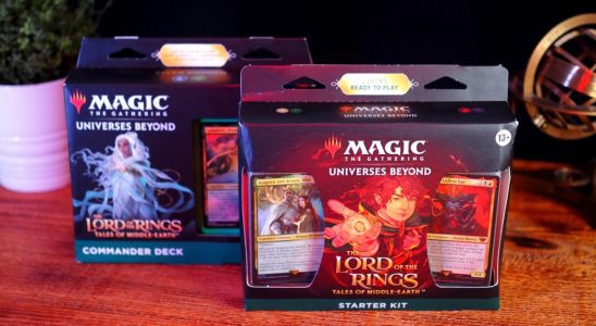 The Starter Set and a Commander deck for MTG Lord of the Rings on a wooden table, beside a plant and a brass object