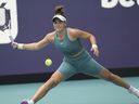 Bianca Andreescu, du Canada, renvoie une volée d'Emma Raducanu, de Grande-Bretagne, dans le premier set d'un match au tournoi de tennis de l'Open de Miami, le mercredi 22 mars 2023, à Miami Gardens, en Floride.