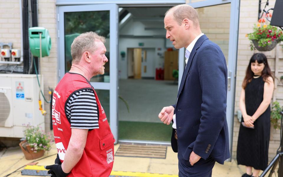 Le prince de Galles rencontre un membre du Mosaic Clubhouse à Brixton lors de sa visite lundi
