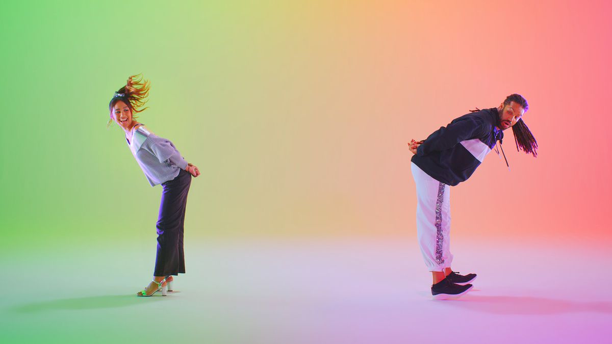 Deux joueurs se penchent, poussant un Joy-Con tenu derrière leur dos, sur une photo promotionnelle de Everybody 1-2-Switch
