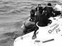 Des plongeurs aident l'équipage secouru de Pisces III.