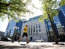 Un jogger passe devant l'édifice de la Banque du Canada à Ottawa.