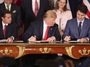 Le président Donald Trump, au centre, regarde le document du premier ministre Justin Trudeau alors qu'eux-mêmes et le président mexicain Enrique Pena Nieto signent le nouvel accord États-Unis-Mexique-Canada à Buenos Aires, en Argentine, le vendredi 30 novembre 2018.
