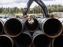 Les tuyaux du pipeline Trans Mountain sont déchargés à Edson, en Alberta. 