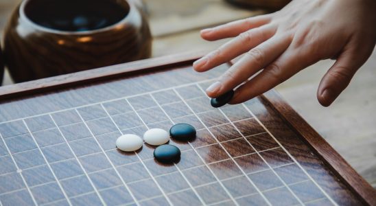 female hand playing the game of go
